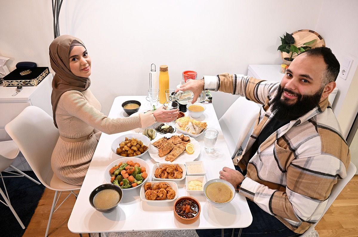 Bild: Två personer sittande vid ett bord fullt av mat.